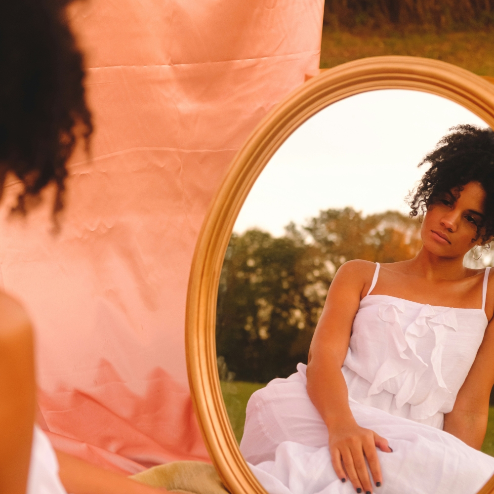 a woman looking in the mirror as she is rebuilding her self image