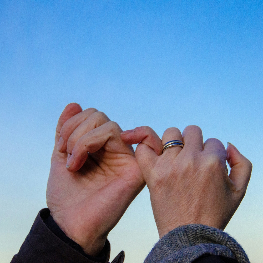 two hands locked together by their pinkies representing trust in relationships